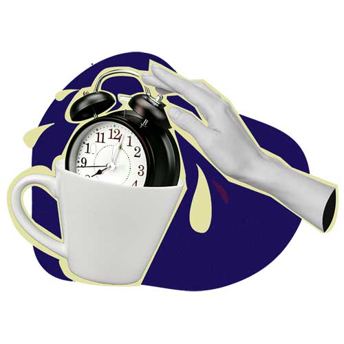 A hand stopping an alarm clock sitting in a coffee mug